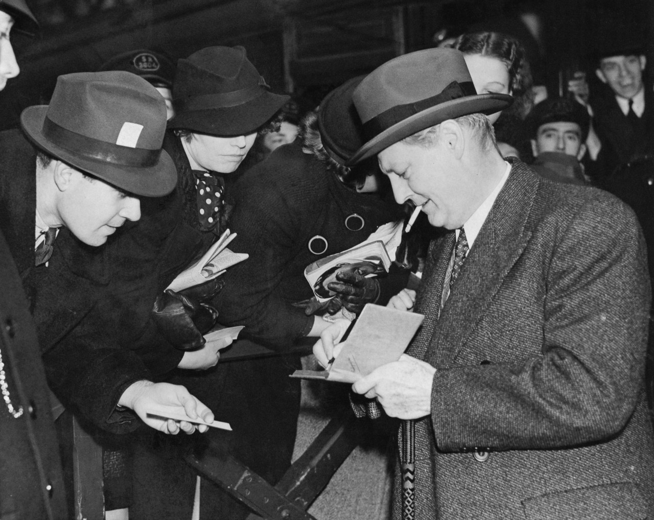 Lionel Barrymore signing autographs at Waterloo Station in London, December 1937