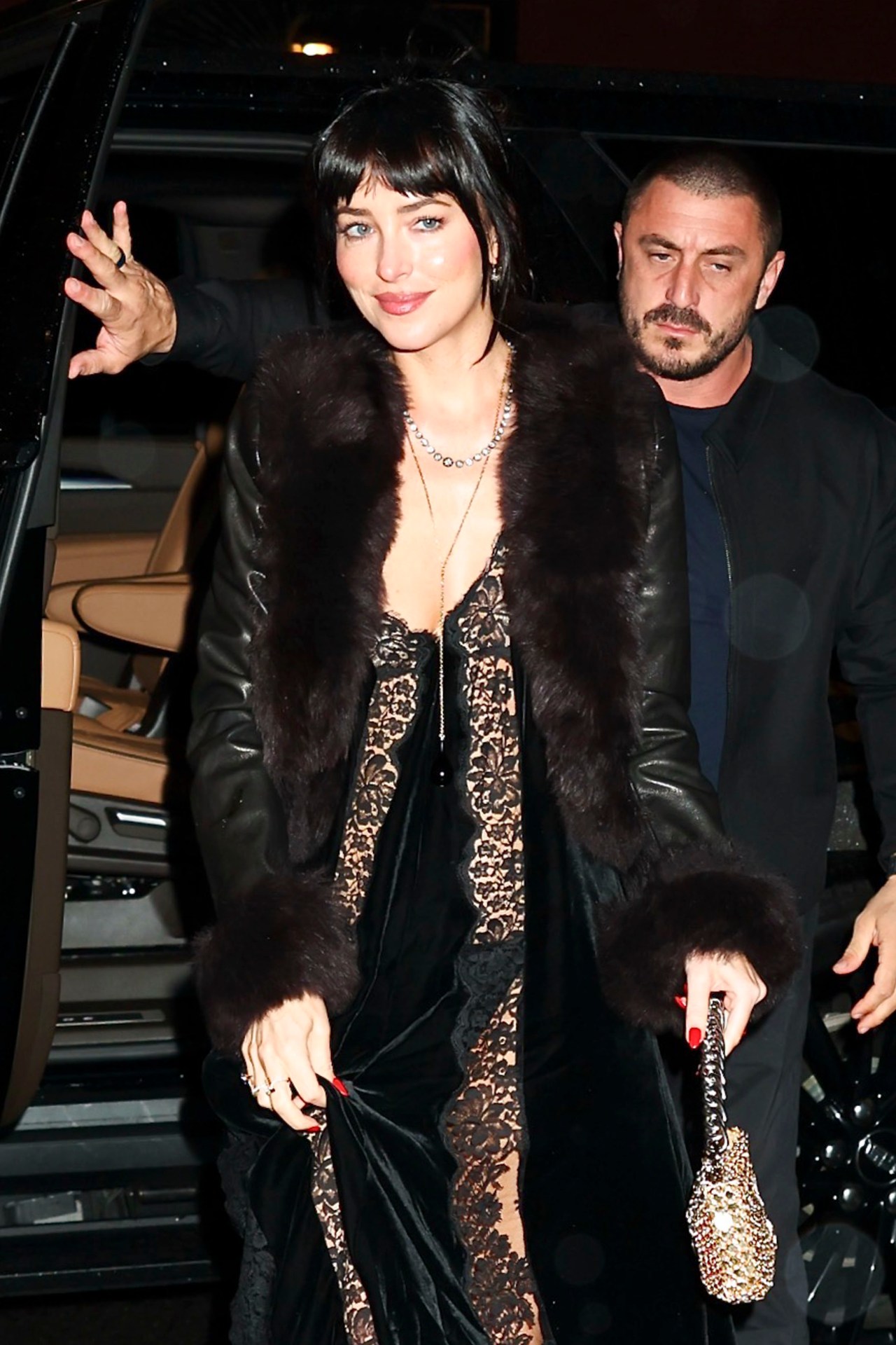 Dakota Johnson in a black Stella McCartney dress and fur-trimmed leather coat arriving at Via Carota restaurant in New York City