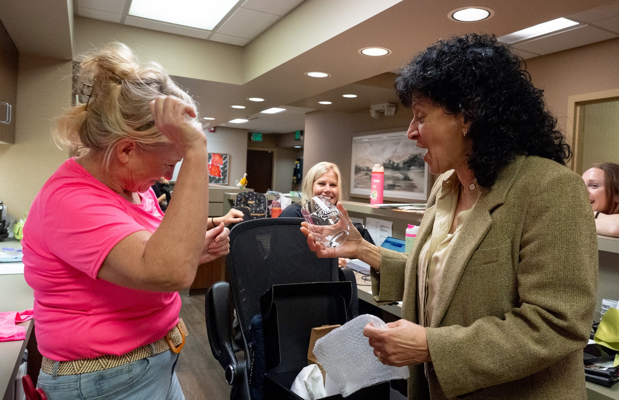 Dr. Cecilia Ellis, who retires after 37 years as an obstetrician and gynecologist, laughs at a wine glass with funny saying from colleagues at OBGYN Associates of Akron on Sept. 30, 2026.