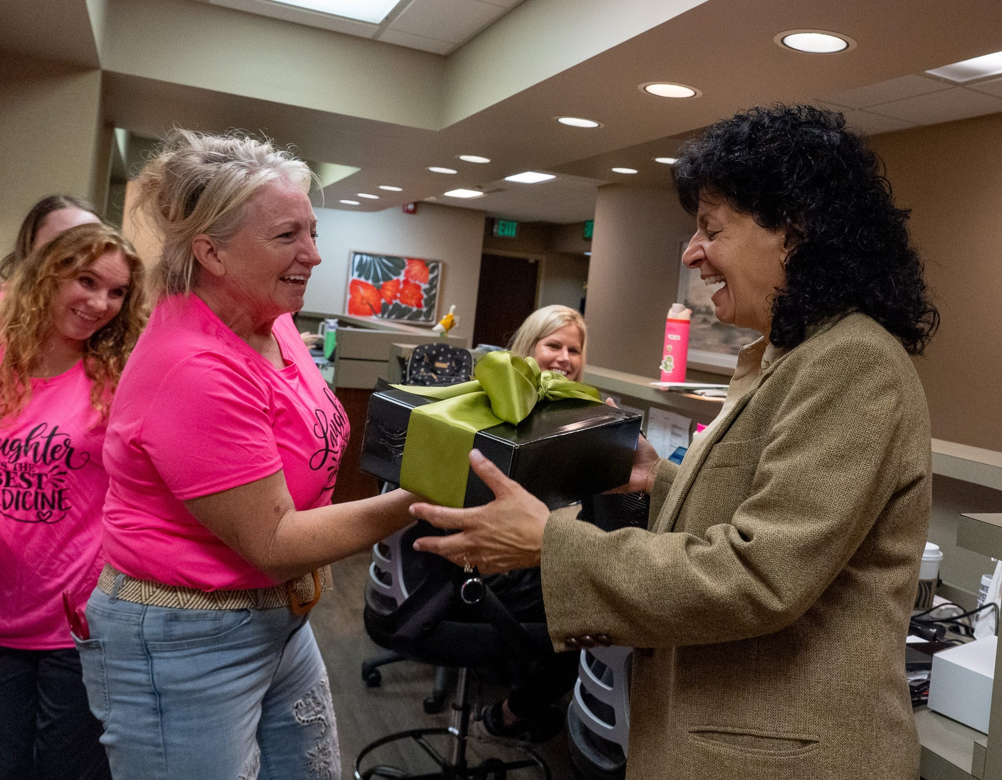 Rachel Clarke, practice manager, hands a gift to Dr. Cecilia Ellis who retires after 37 years as an obstetrician and gynecologist at OBGYN Associates of Akron on Sept. 30, 2026.