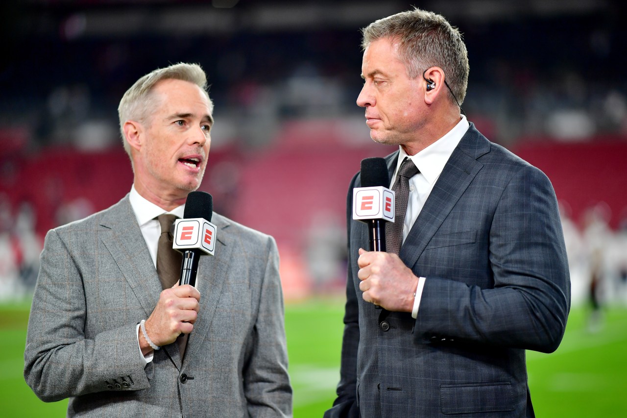 Joe Buck and Troy Aikman standing together in the broadcast booth before an NFL playoff game