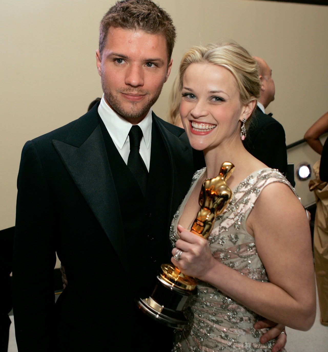Reese Witherspoon holding her Oscar statuette next to Ryan Phillippe at the Academy Awards Governor's Ball in 2006