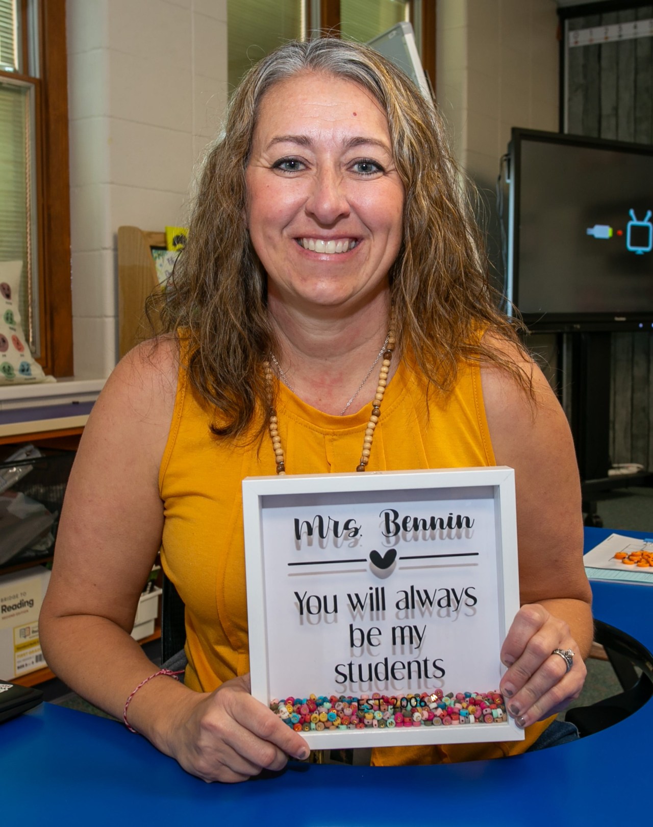 Teacher Sarah Bennin holding a bead-filled shadow box in her first grade classroom in Sheboygan Falls, Wisconsin
