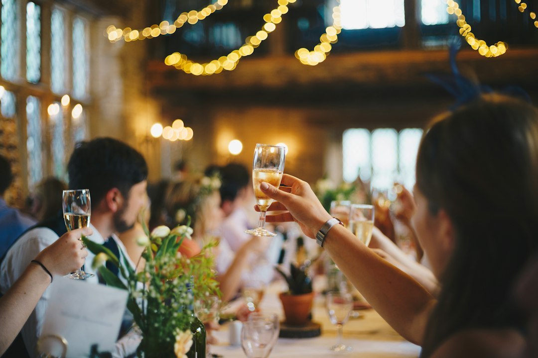 Guests raising champagne glasses in a toast at a wedding reception