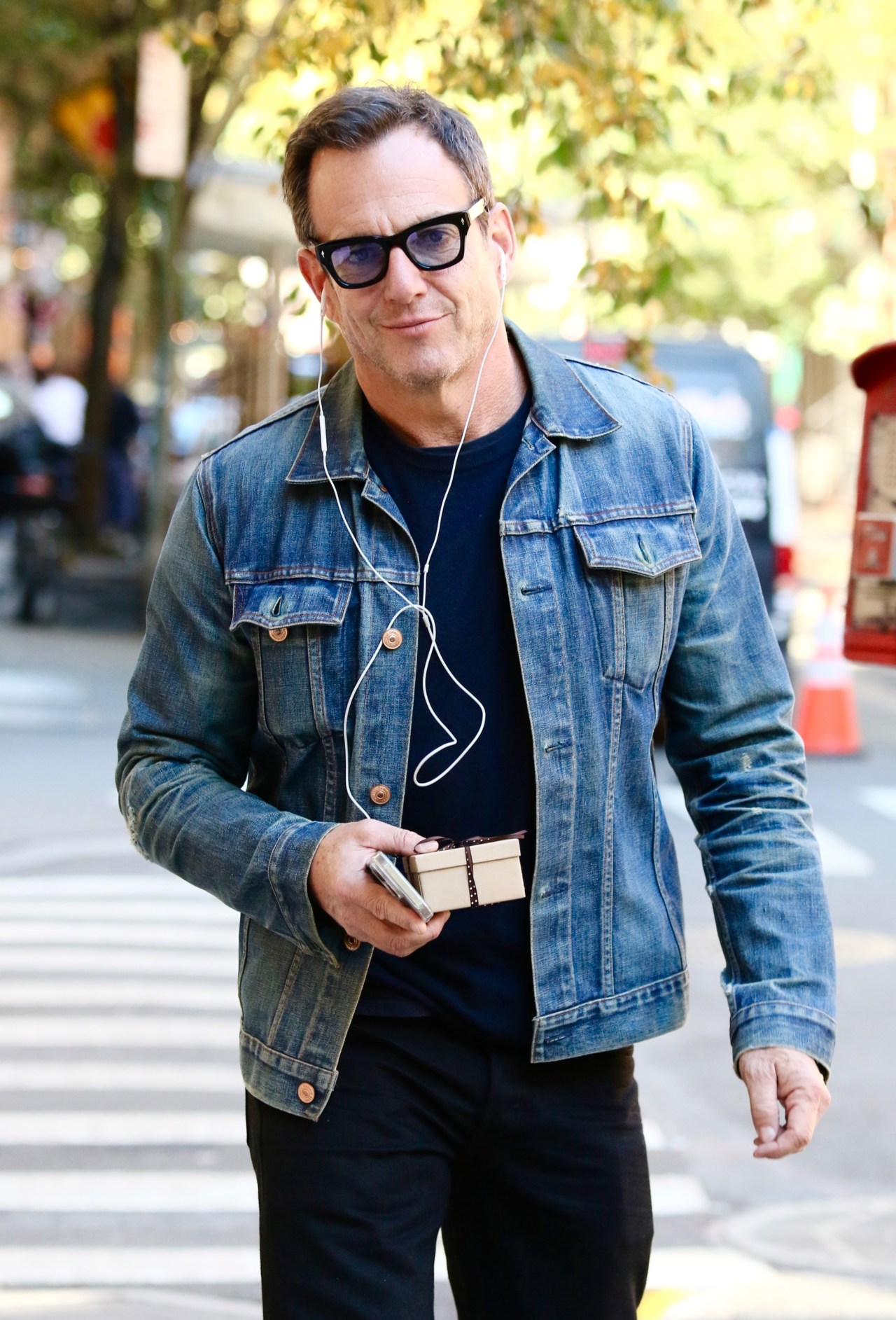 Will Arnett walking in downtown Manhattan carrying a small wrapped present